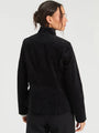 Woman wearing a luxury black velvet blazer jacket, back view.