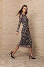 Woman wearing a long-sleeved floral print midi dress and black high heel sandals.