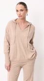 Woman wearing a beige cashmere hoodie and matching knit trousers