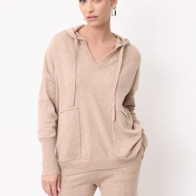 Woman wearing a beige cashmere hoodie and matching knit trousers