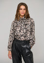 Woman wearing a leopard print long-sleeve blouse with a pussy bow neck and black leather trousers.