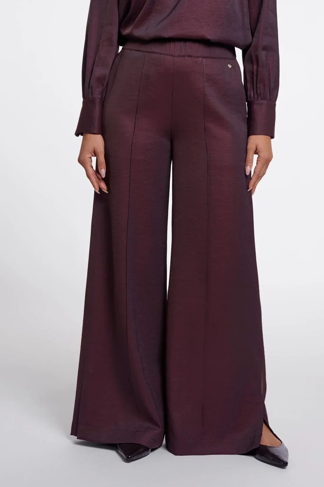 Women's luxury wide-leg trousers in deep burgundy silk fabric.