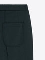 Close-up of a dark green designer skirt featuring a back patch pocket.
