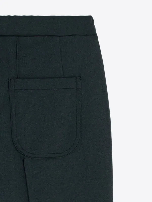 Close-up of a dark green designer skirt featuring a back patch pocket.